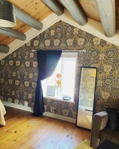 a room with a window and a wall covered in wallpaper at Hova Prästgård Bed & Breakfast in Hova