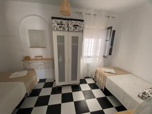 a room with two beds and a checkered floor at CASA RETINTO in Vejer de la Frontera