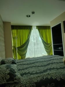 um quarto com uma cama e uma grande janela em HOSPEDAJE YACUCALLE em Ibarra