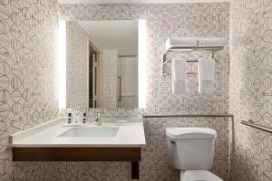 uma casa de banho com um lavatório, um WC e um espelho. em Holiday Inn Orlando International Airport, an IHG Hotel em Orlando