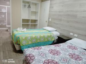 een kamer met 2 bedden in een kamer bij HOSPEDAJE YACUCALLE in Ibarra
