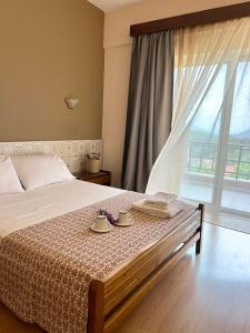 1 dormitorio con 1 cama con 2 tazas y una ventana en Βαδόκειος ΓΗ, en Zítsa