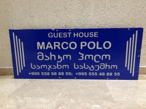 Un panneau bleu qui dit la maison d'hôtes marco polo dans l'établissement Marco Polo, à Koutaïssi