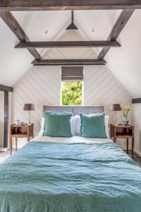 a bedroom with a large bed with blue pillows at The Lakeside Viewing Gallery in Shiplake
