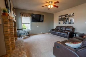 a living room with a couch and a ceiling fan at Hillcrest Chalet - Spa - Mountain Views - Fire Pit - Slide -9min to USAFA in Colorado Springs
