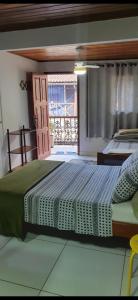 ein Schlafzimmer mit einem großen Bett und einem Fenster in der Unterkunft Angel Ilha Flats e Varanda da Praia in Abraão