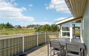 a wooden deck with a table and chairs on it at Stunning Home In Thisted With 4 Bedrooms, Sauna And Wifi in Nørre Vorupør