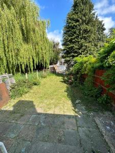 a yard with a fence and trees and grass at 4 Bed Family Home in Woodford Green