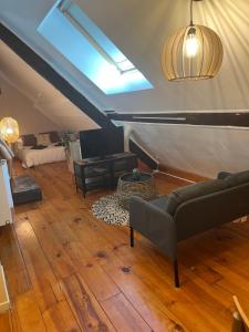 a living room with a couch and a tv at Couette et Tartine in Chalon-sur-Saône