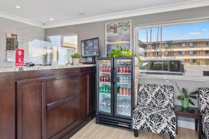 a drink bar with two chairs and a refrigerator at Vagabond Inn Whittier in Whittier