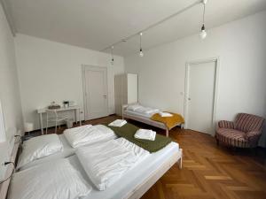 a white room with a bed and a chair at House Elza in Ljubljana