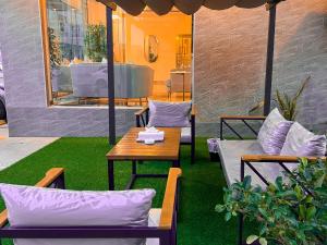 d'une terrasse avec des chaises, une table et un sidx. dans l'établissement Daar AL Maqam Suites Apartments Salalah, à Salalah