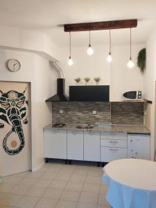 a kitchen with white cabinets and a spider on the wall at Apartments Blanca in Vodice