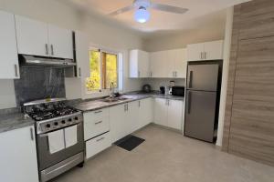 una cucina con armadietti bianchi ed elettrodomestici in acciaio inossidabile di Estrella Residences - Two Bedroom a Cabarete