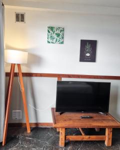 un salon avec une télévision et une table avec une lampe dans l'établissement El Cencerro Bariloche, à San Carlos de Bariloche