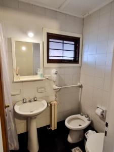 La salle de bains est pourvue d'un lavabo, de toilettes et d'un miroir. dans l'établissement El Cencerro Bariloche, à San Carlos de Bariloche