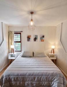 - une chambre avec un grand lit et deux lampes dans l'établissement El Cencerro Bariloche, à San Carlos de Bariloche