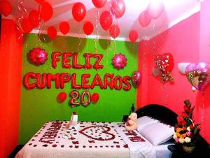 a room with a bed with a sign and balloons at Hotel San Francisco in Cajamarca