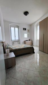 a bedroom with a bed and a table and windows at UN BALCONE IN PINETA in Fezzano