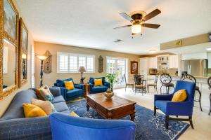 a living room with blue couches and a table at Near Busch Gardens Sunny Florida Retreat with Pool! in Palm Harbor