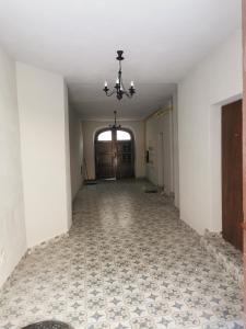 un corridoio vuoto con lampadario pendente e pavimento piastrellato di Town Square Apartment a Lublino
