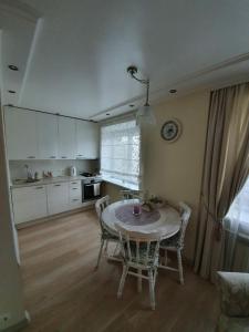a kitchen with a table and chairs in a room at Cozy centre apartment KKE in Ventspils