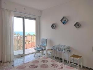 Habitación con 2 sillas, mesa y ventana en CASA FRONTE MARE, en Ventimiglia