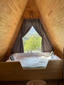 a bathroom with a large bath tub with a window at Doğanın İçinde Lüks Jakuzili Balayı Bungalovu(роскошное шале с джакузи) in Kumluca