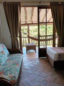 a room with two beds and a large window at Casona CHARA in Barichara