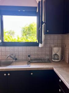 a kitchen counter with a sink and a window at Sea and Stone Villa in Afitos +62 photos