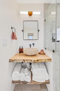 a bathroom with a sink and a shelf with towels at The Grand Canyon Headquarters in Valle