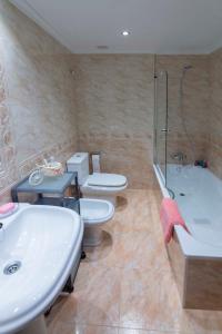 łazienka z 2 toaletami, umywalką i wanną w obiekcie APARTAMENTO COSTA CANTABRIA w mieście Cuchia
