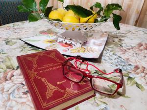 ein Buch und eine Brille auf einem Tisch mit einer Schale Zitronen in der Unterkunft ALYSSA SWEET DREAMS -Holidays House in Sora + 33 Fotos