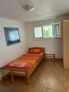 a small bedroom with a bed and a tv at Apartments Jankovic in Podgorica