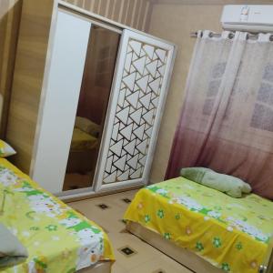 a bedroom with two beds and a mirror at شقة مفروشة سوبر لوكس للايجار in Cairo