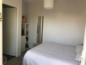 1 dormitorio con cama blanca y armario en les aulnes de sanguinet, en Sanguinet