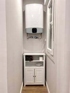 a small white cabinet in a hallway with a window at NEURE KABIA urban studio in Bermeo