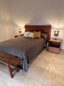 1 dormitorio con 1 cama con 2 mesas y 2 lámparas en CASA CUTI en Reconquista