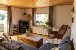 a living room with a couch and a table at Gezellig ruim landelijk huisje aan het water in Spijkenisse