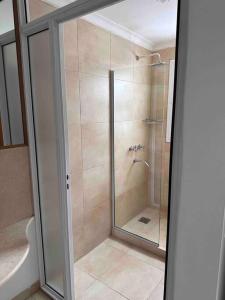 um chuveiro com uma porta de vidro na casa de banho em CASA CUTI em Reconquista