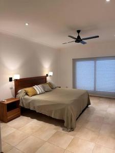 um quarto com uma cama e uma ventoinha de tecto em CASA CUTI em Reconquista