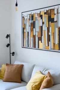 a living room with a couch with a painting on the wall at Cozy City Apartment in Graz
