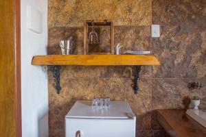 a bathroom with a sink and a shelf on a wall at Pousada Chales Rancho Caipira in Santo Antônio do Pinhal