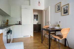 a kitchen and dining room with a table and chairs at Cozy City Apartment in Graz +4 photos