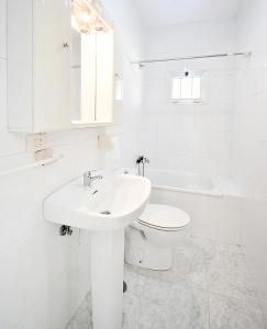 ein weißes Badezimmer mit Waschbecken und Toilette in der Unterkunft GALIHOST - Casa con jardín en Cambados in Cambados