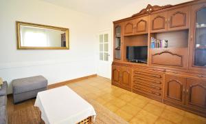 ein Wohnzimmer mit einem großen Unterhaltungszentrum aus Holz in der Unterkunft GALIHOST - Casa con jardín en Cambados in Cambados