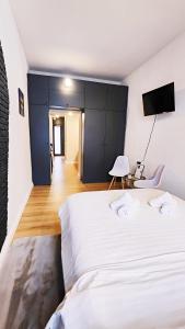 1 dormitorio con 1 cama blanca grande y TV en Bridge View Studio en Sibiu