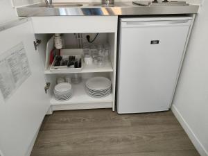 a white refrigerator in a kitchen with dishes at T2 Toulouse centre in Toulouse