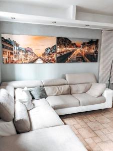 a living room with a white couch and a painting at La Villa di Bambi in Vanzago