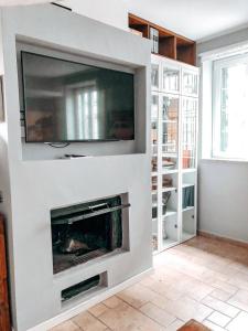 a living room with a tv and a fireplace at La Villa di Bambi in Vanzago